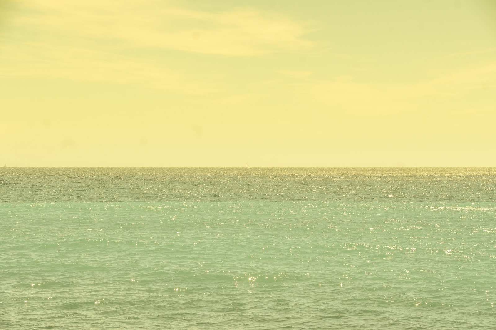 Voilier au loin sur une mer turquoise