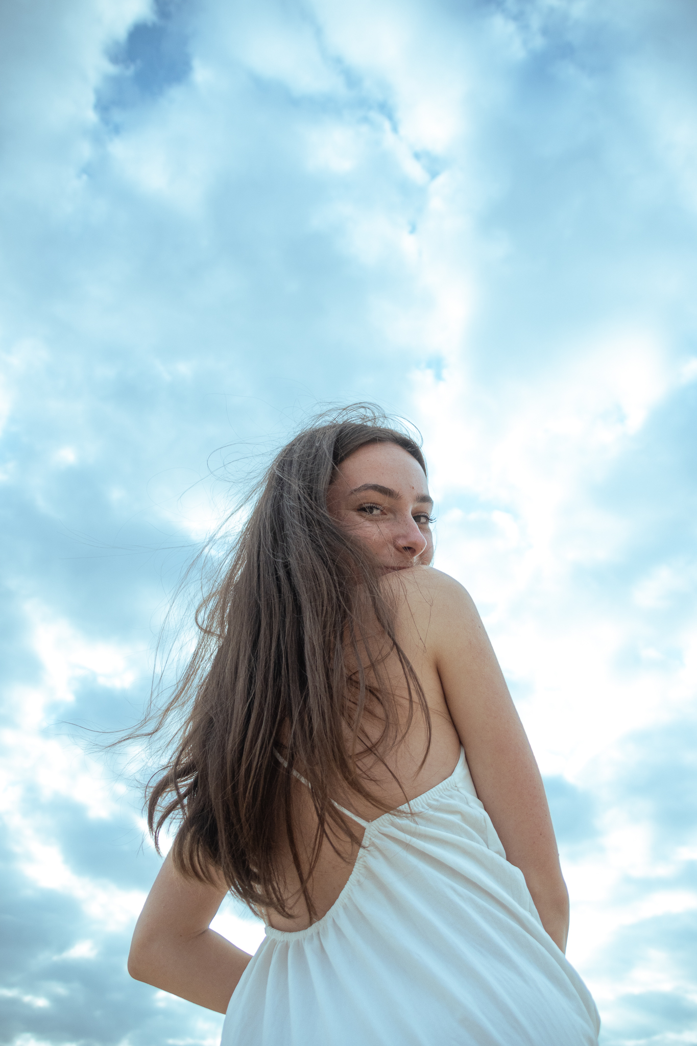 Sophie — portrait en contre-plongée, ciel nuageux